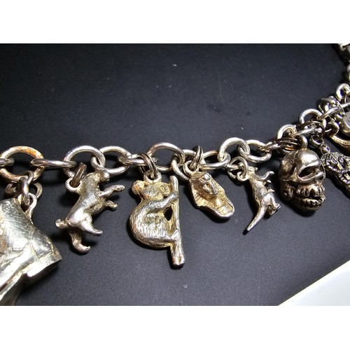 311 - A good quality vintage 925 silver charm bracelet featuring 14 different charms to include an articul... 