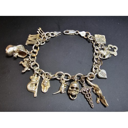 311 - A good quality vintage 925 silver charm bracelet featuring 14 different charms to include an articul... 