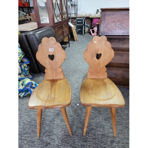 492 - Pair of matching light oak Tyrolean Mid Century chairs both have a carved floral shaped back with a ... 