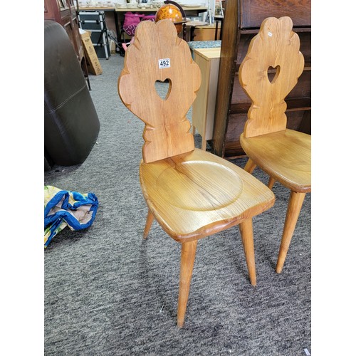 492 - Pair of matching light oak Tyrolean Mid Century chairs both have a carved floral shaped back with a ... 