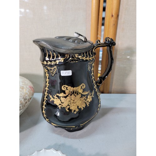 325 - A shelf full of collectable ceramic to include a good Victorian black lidded jug with a gilt design ... 