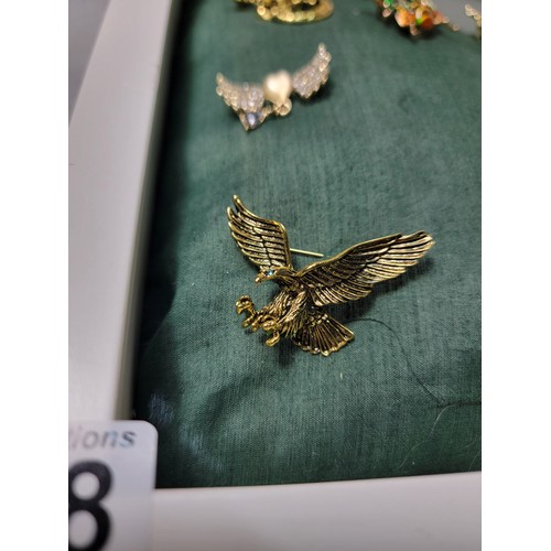 258 - A suite of 10 ornate costume brooches fitted on a good display board (included) which includes 3 orn... 