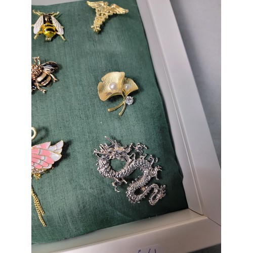 258 - A suite of 10 ornate costume brooches fitted on a good display board (included) which includes 3 orn... 