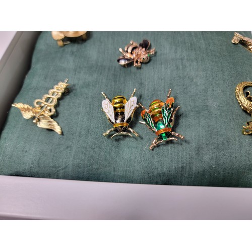 258 - A suite of 10 ornate costume brooches fitted on a good display board (included) which includes 3 orn... 