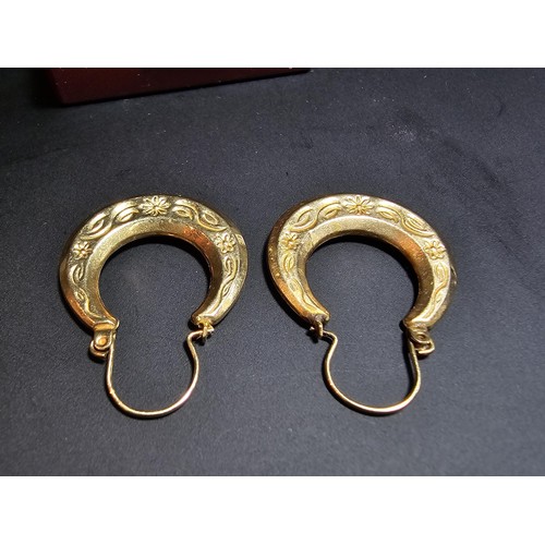 357 - A pair of large 9ct horseshoe shaped drop earrings with an engraved design in excellent clean condit... 