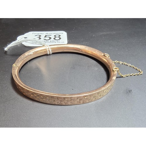 358 - A good quality vintage 9ct rose gold hinged bangle featuring an engraved design complete with its sa... 