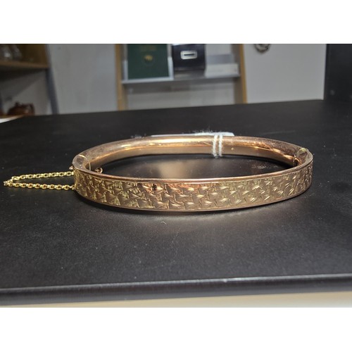 358 - A good quality vintage 9ct rose gold hinged bangle featuring an engraved design complete with its sa... 