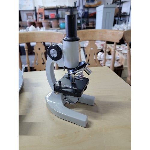 68 - Cased microscope inc  a large quantity of accessories spare lenses etc along with a microscope book