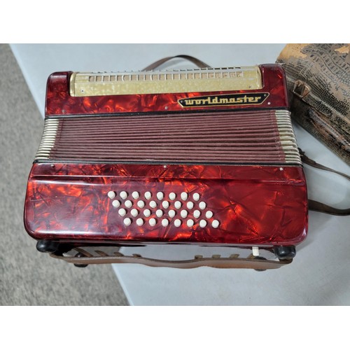 192 - Cased piano accordion by worldmaster, student model, bellows on the accordion are intact, some mould... 