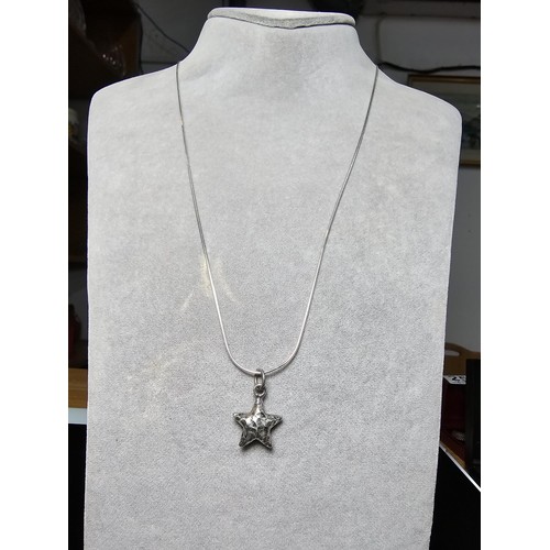 263 - A good quality 925 silver hand hammered star pendant set on a good quality long 22