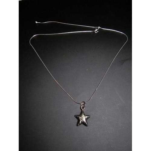 263 - A good quality 925 silver hand hammered star pendant set on a good quality long 22