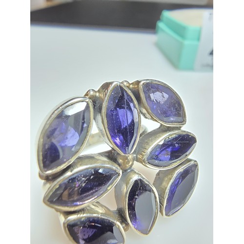 265 - A chunky 925 silver statement ring inset with 8x large faceted iolite gemstones presenting an excell... 