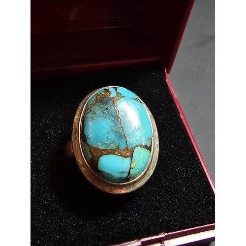 270 - A stunning 925 silver statement ring inset with a large natural oval turquoise stone featuring coppe... 