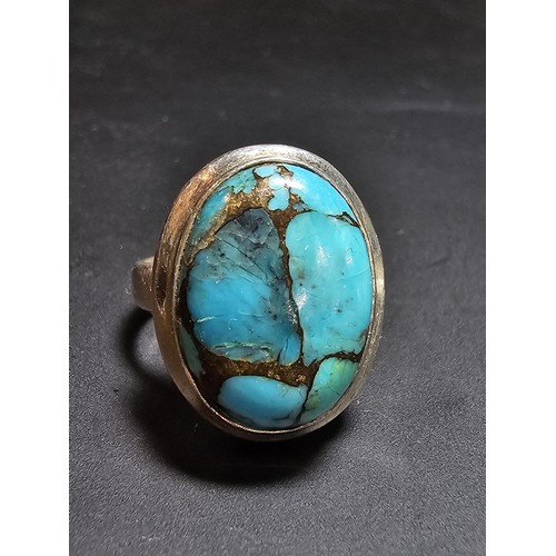 270 - A stunning 925 silver statement ring inset with a large natural oval turquoise stone featuring coppe... 