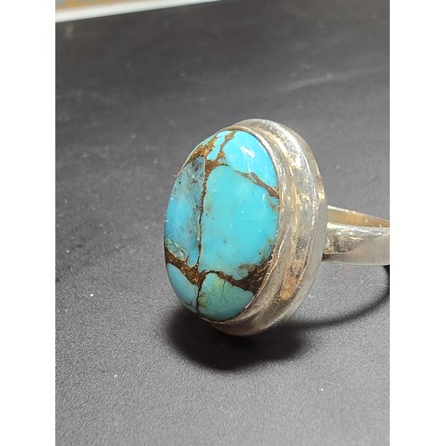 270 - A stunning 925 silver statement ring inset with a large natural oval turquoise stone featuring coppe... 