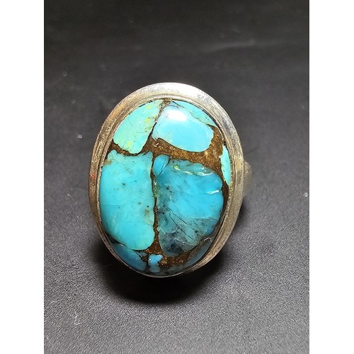 270 - A stunning 925 silver statement ring inset with a large natural oval turquoise stone featuring coppe... 