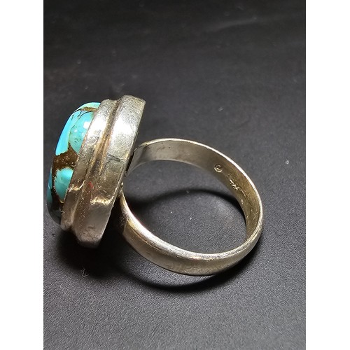 270 - A stunning 925 silver statement ring inset with a large natural oval turquoise stone featuring coppe... 