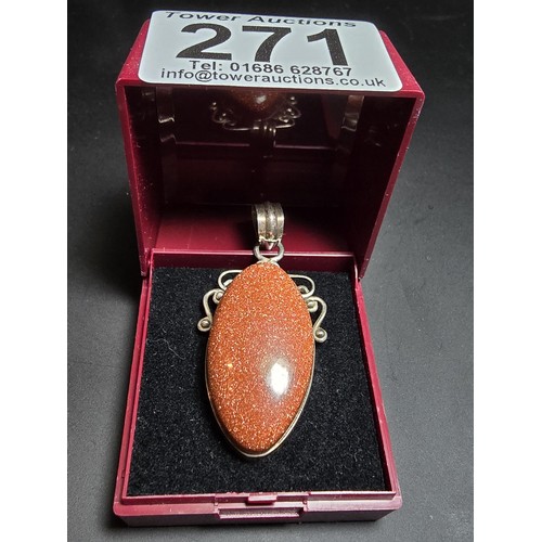 271 - A large 925 silver pendant inset with a large oval gold stone presenting a vibrant orange colour wit... 