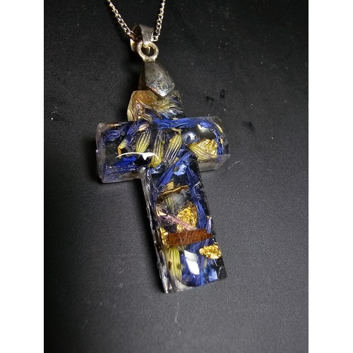 273 - An unusual cross pendant made out of resin inset with real dried flowers and gold leaf set on a 925 ... 