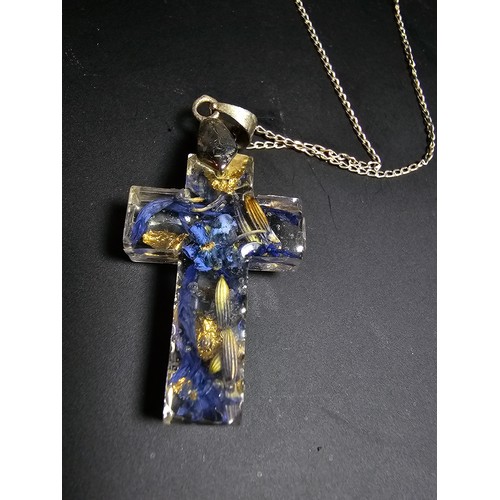 273 - An unusual cross pendant made out of resin inset with real dried flowers and gold leaf set on a 925 ... 