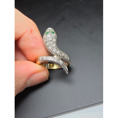 274 - An ornate gold and 925 silver snake formed ring featuring a gold plated silver band , the snake is i... 