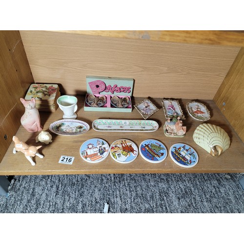 216 - Shelf containing a quantity of collectables inc pin dishes, place mats, figurines etc inc a pair of ... 