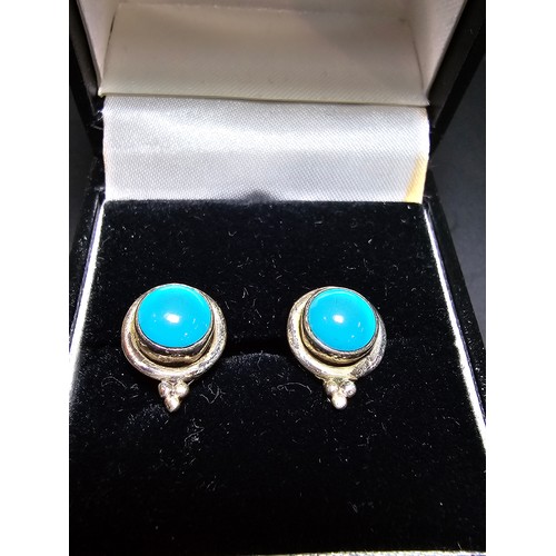 282 - A pair of pretty 925 silver stud earrings inset with blue turquoise cabochon stones, complete with b... 