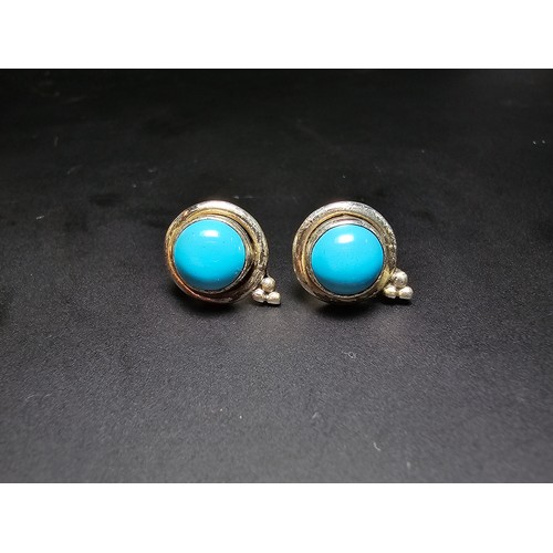 282 - A pair of pretty 925 silver stud earrings inset with blue turquoise cabochon stones, complete with b... 