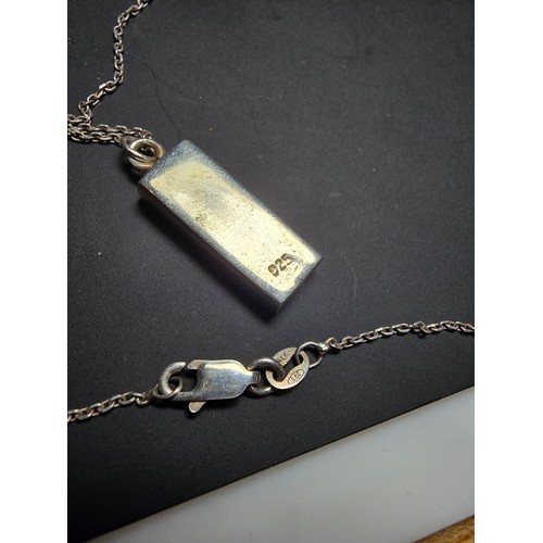 286 - A chunky 925 silver bar pendant inset with mother of pearl and having good flashing colours set on a... 