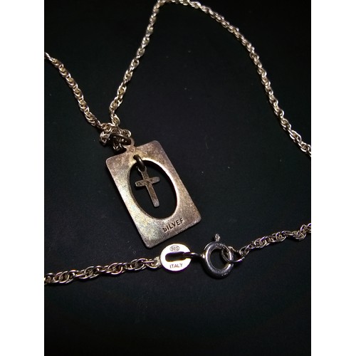 295 - A 925 silver pendant featuring a dangling cross within a silver frame set on a good 16