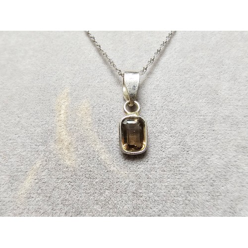 296 - An as new 925 silver pendant inset with a good faceted smokey quartz gemstone set on a long 18