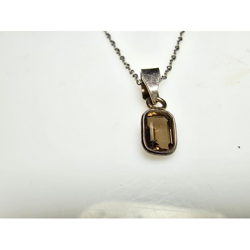 296 - An as new 925 silver pendant inset with a good faceted smokey quartz gemstone set on a long 18