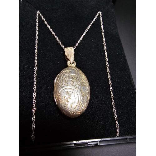 297 - A pretty 925 silver engraved locket set on an 18