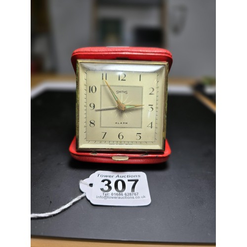 307 - An attractive vintage genuine red leather cased Smiths alarm travel clock with a clam style opening.... 