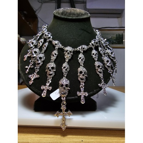 311 - An unusual silver tone ornate necklace featuring a large quantity of skull and cross drops. Beautifu... 