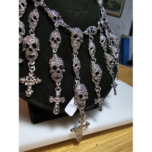 311 - An unusual silver tone ornate necklace featuring a large quantity of skull and cross drops. Beautifu... 