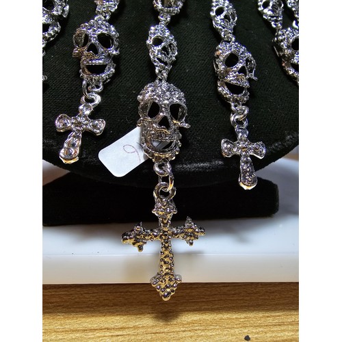 311 - An unusual silver tone ornate necklace featuring a large quantity of skull and cross drops. Beautifu... 