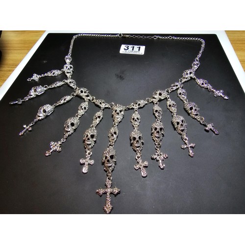 311 - An unusual silver tone ornate necklace featuring a large quantity of skull and cross drops. Beautifu... 