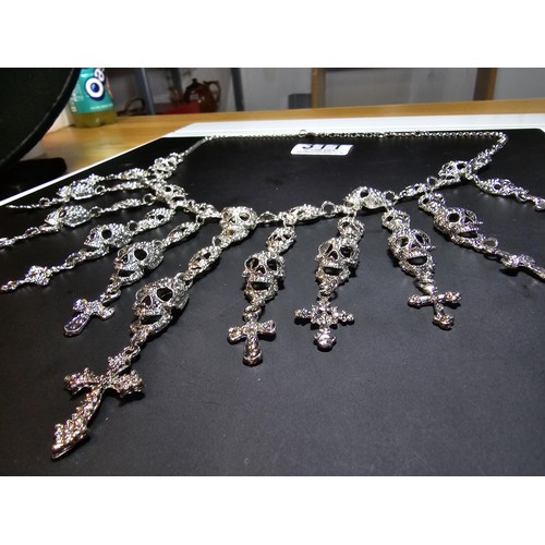 311 - An unusual silver tone ornate necklace featuring a large quantity of skull and cross drops. Beautifu... 