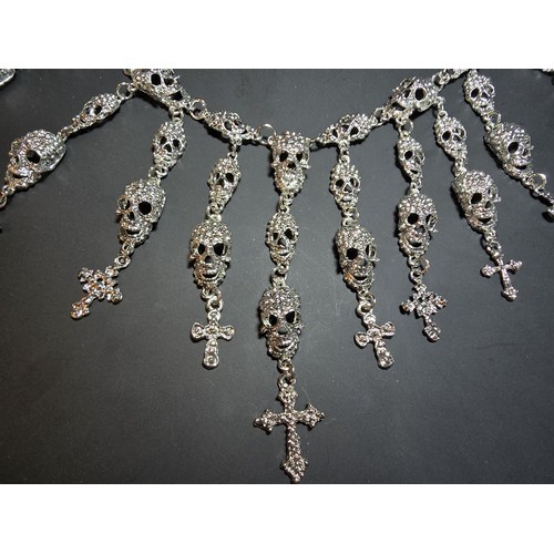 311 - An unusual silver tone ornate necklace featuring a large quantity of skull and cross drops. Beautifu... 