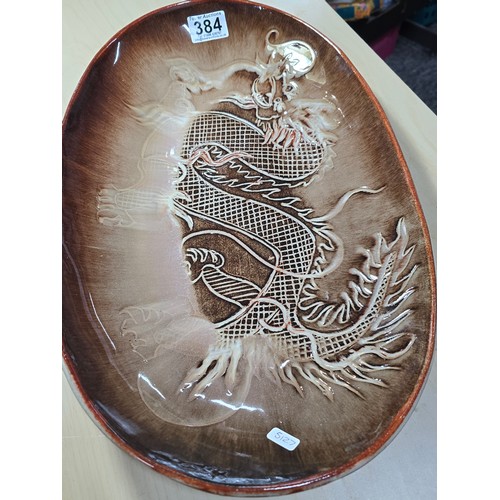 384 - Large and impressive terracotta pottery glazed charger with an incised dragon design by Campden Pott... 