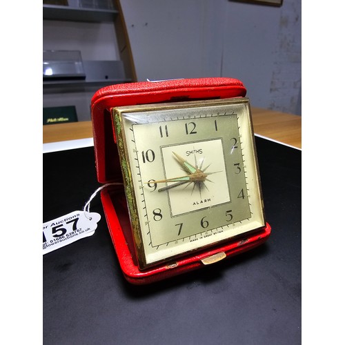 157 - An attractive genuine red leather vintage Smiths travel alarm clock in a clam style case along with ... 