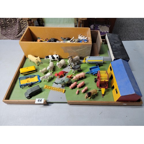 44 - A toy wooden farm set with 3 out houses, along with a large quantity of farm animals, zoo animals, f... 