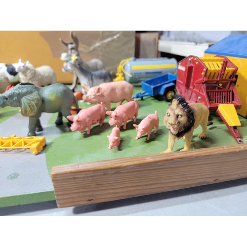 44 - A toy wooden farm set with 3 out houses, along with a large quantity of farm animals, zoo animals, f... 