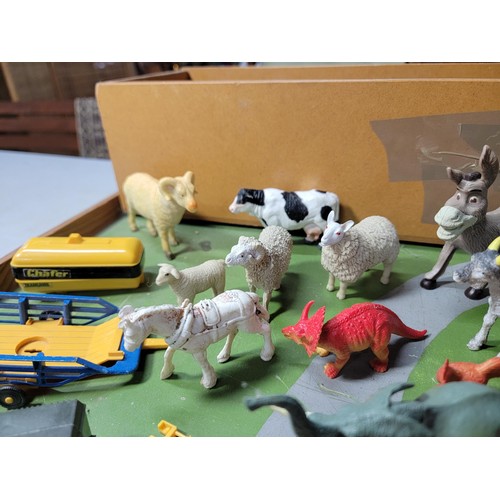 44 - A toy wooden farm set with 3 out houses, along with a large quantity of farm animals, zoo animals, f... 