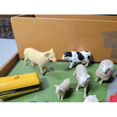 44 - A toy wooden farm set with 3 out houses, along with a large quantity of farm animals, zoo animals, f... 