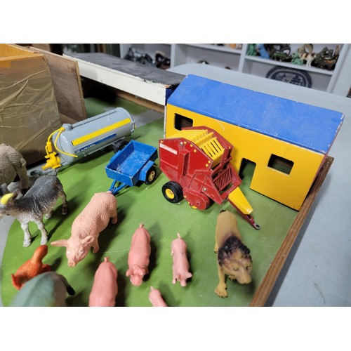 44 - A toy wooden farm set with 3 out houses, along with a large quantity of farm animals, zoo animals, f... 