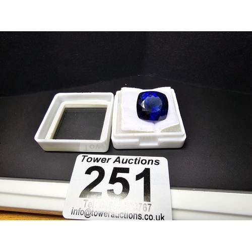 251 - A cased large lab created cushion cut faceted blue sapphire gemstone complete with its presentation ... 