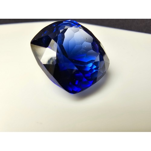 251 - A cased large lab created cushion cut faceted blue sapphire gemstone complete with its presentation ... 