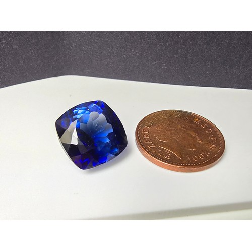 251 - A cased large lab created cushion cut faceted blue sapphire gemstone complete with its presentation ... 